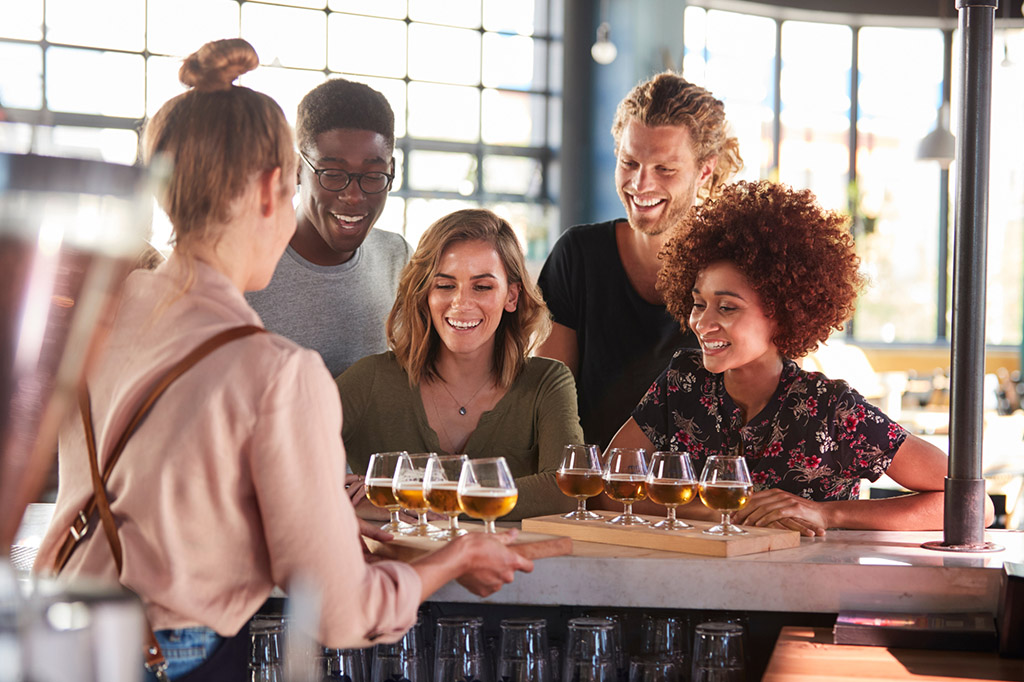  four friends sample beer flights at a craft brewery