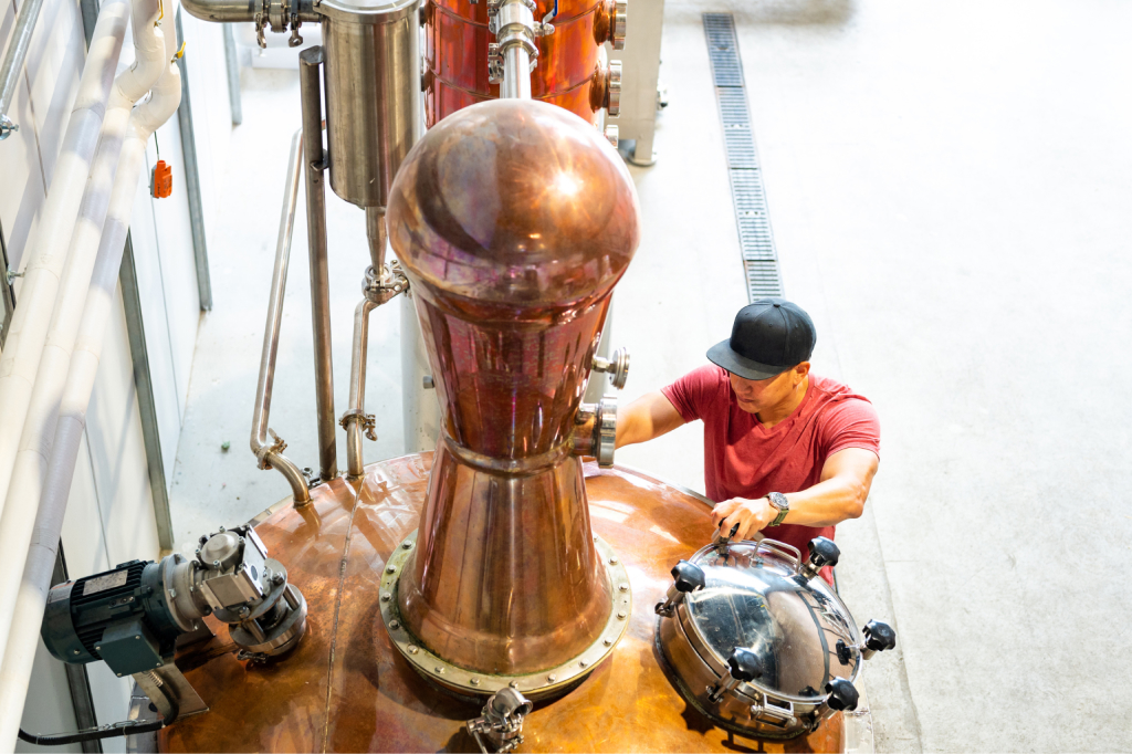 a master distiller inspects a still during the production process
