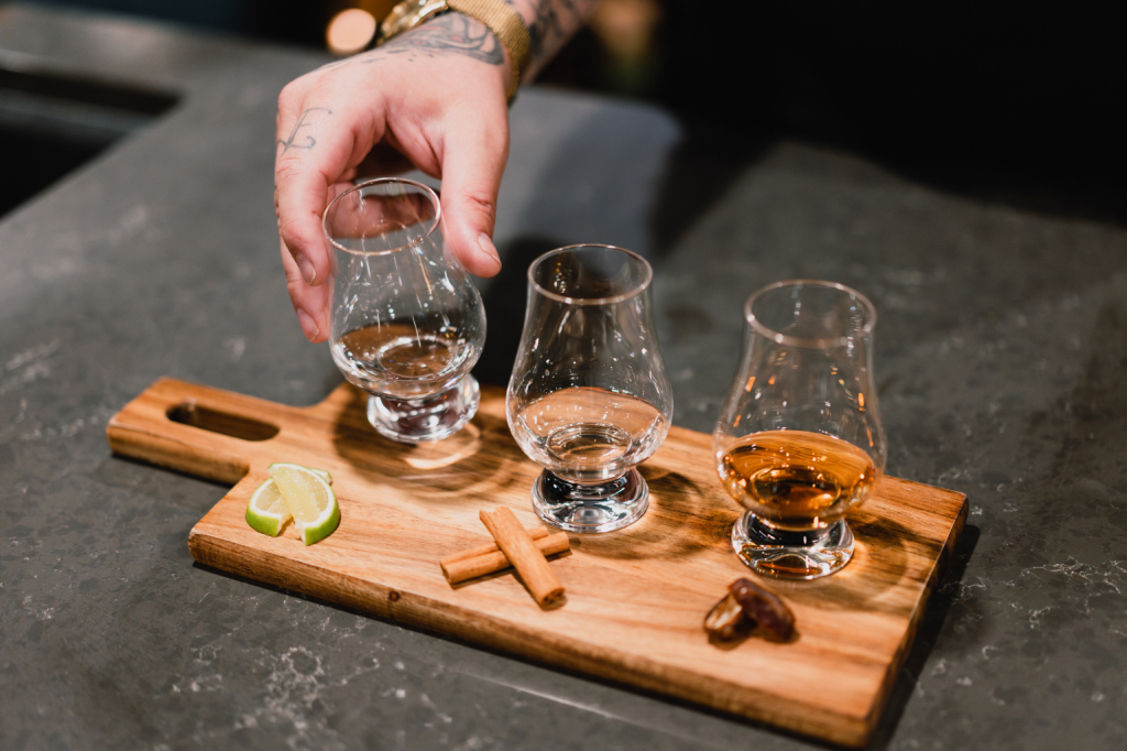  a craft distillery tasting room with three types of spirits and accompaniments for sampling 
