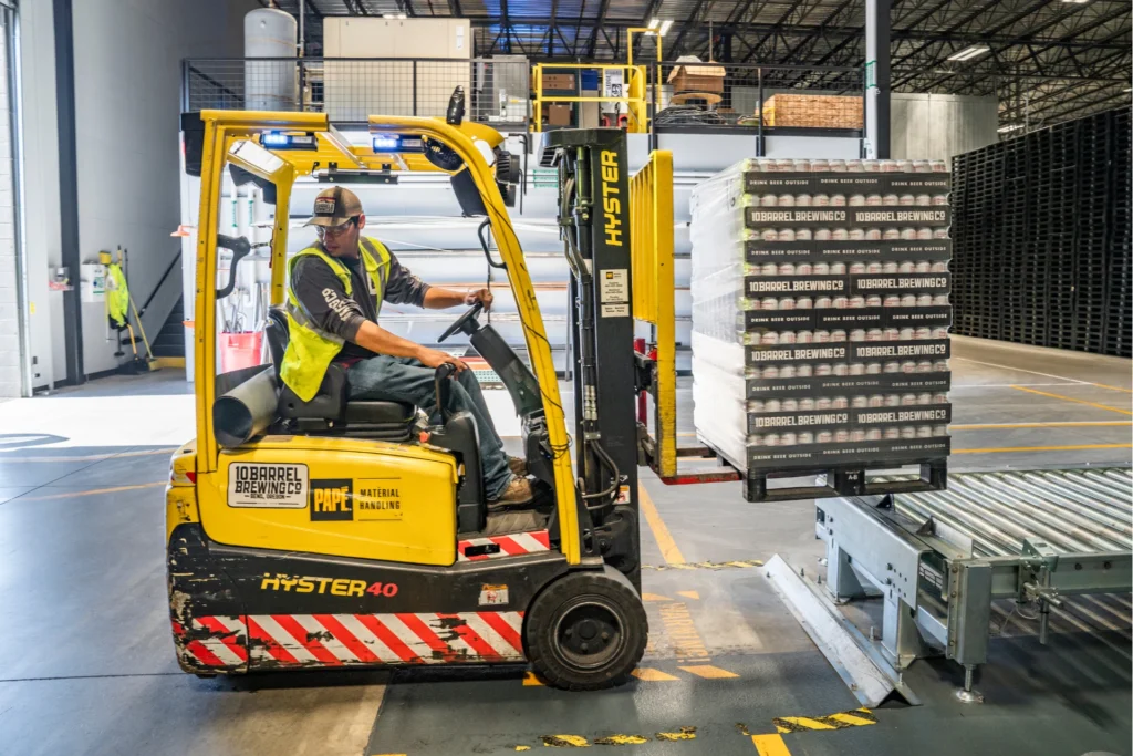 Forklift operator moving a pallet of brewed beverage