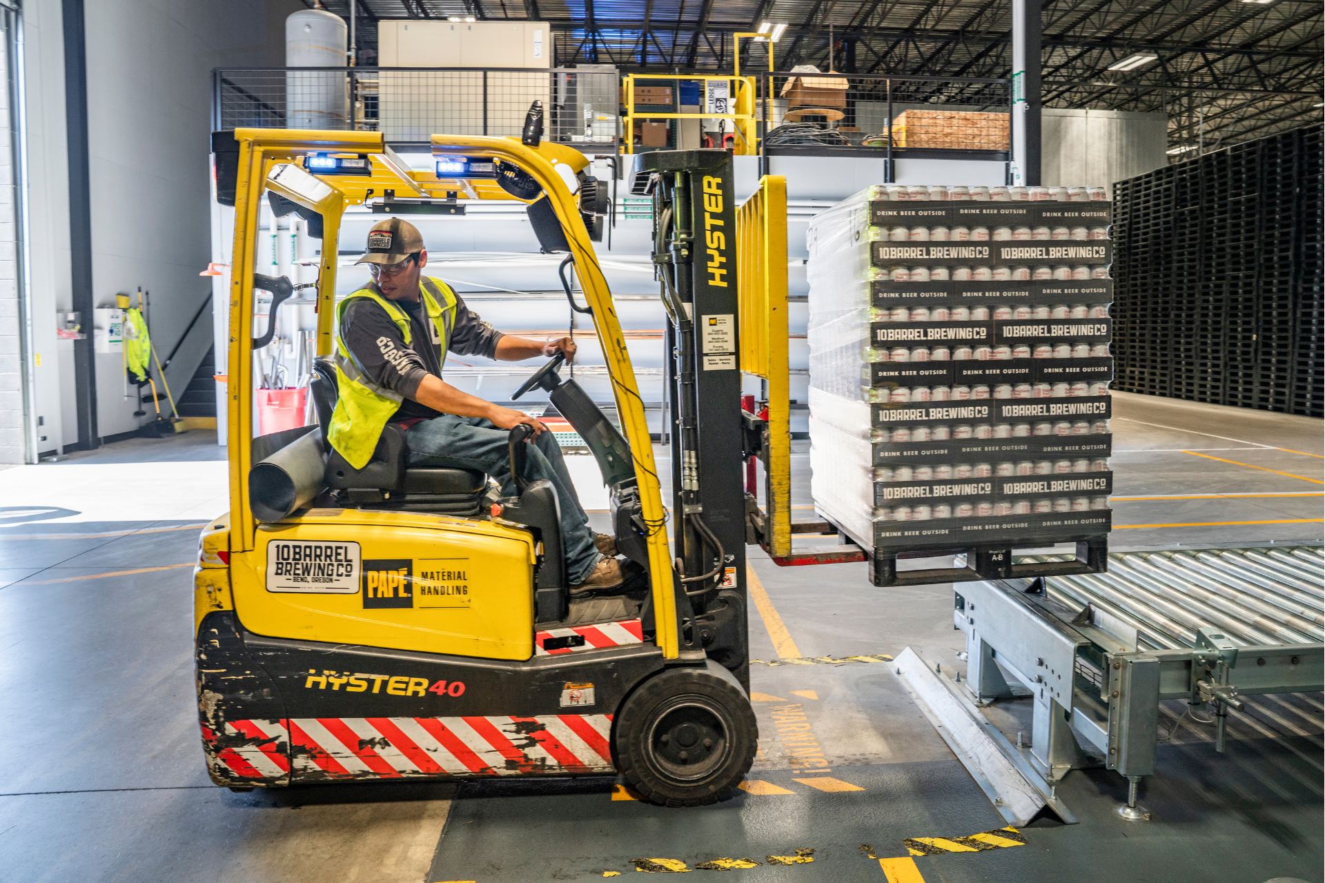 Forklift operator moving pallet of brewed beverage