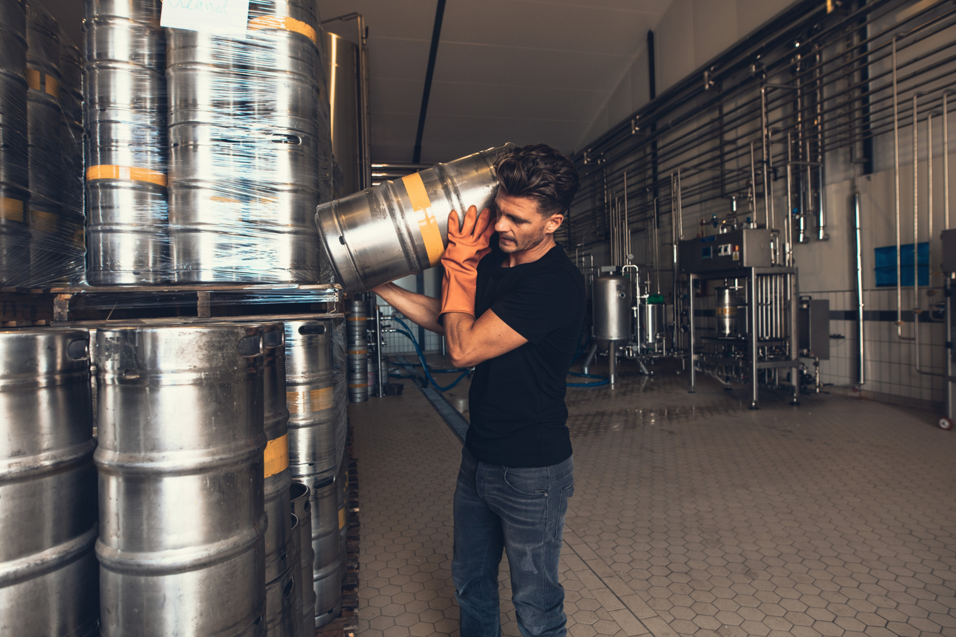 Worker stacking beer kegs