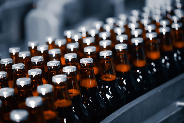 Rows of brown beer bottles in factory