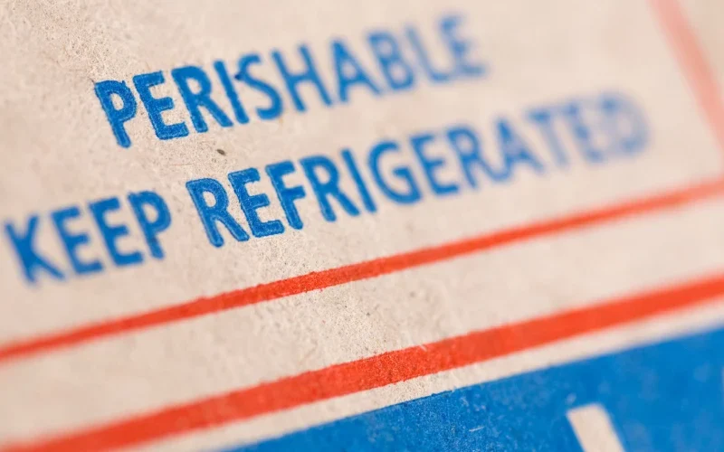 A closeup of a box with the words “perishable, keep refrigerated” written on it.