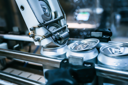 he lid being added to cans on a conveyor belt in a brewery