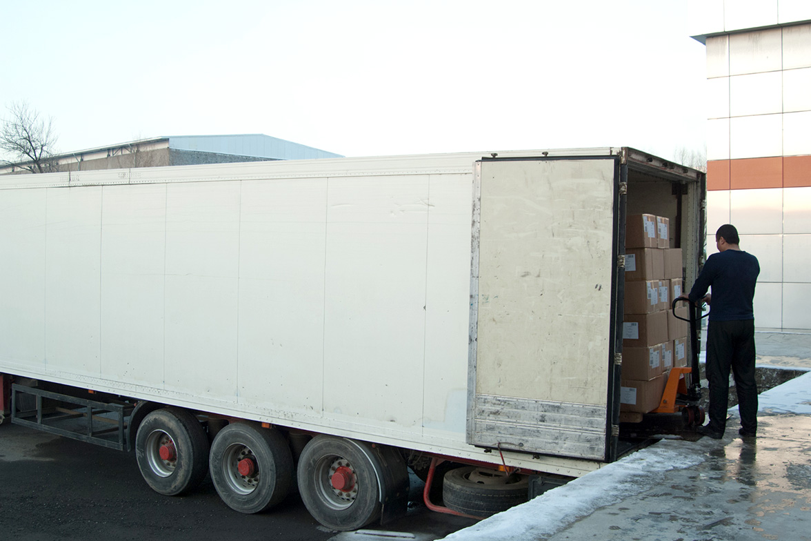 A delivery person loading boxes into a truck