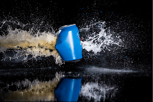 text: liquid exploding out of a damaged aluminum can