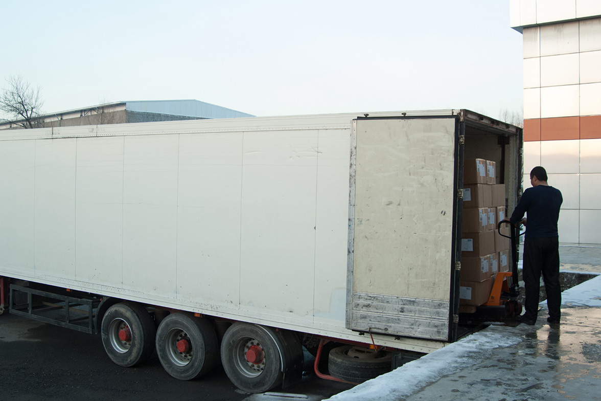 A white truck getting loaded with boxes