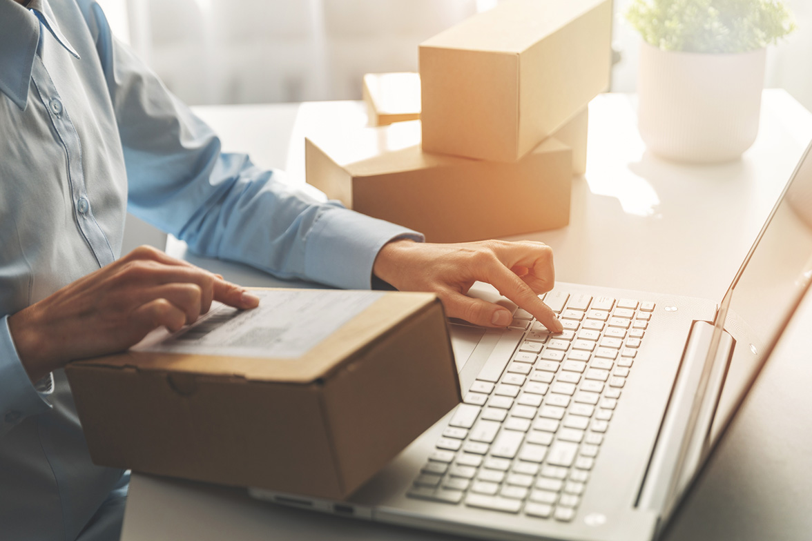 Shipper using a laptop with parcels on the table