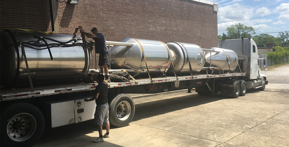 Two men preparing a transport truck for departure 