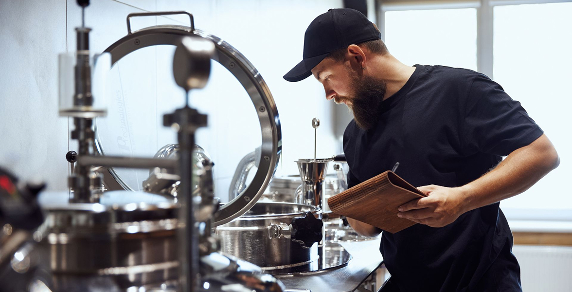 A man checking beer brewing equipment