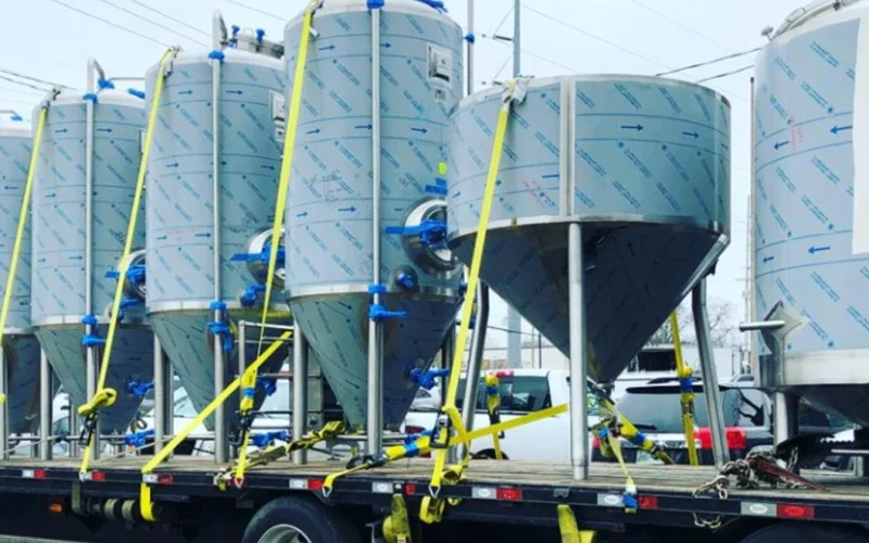 several distillery tanks being transported on a truck