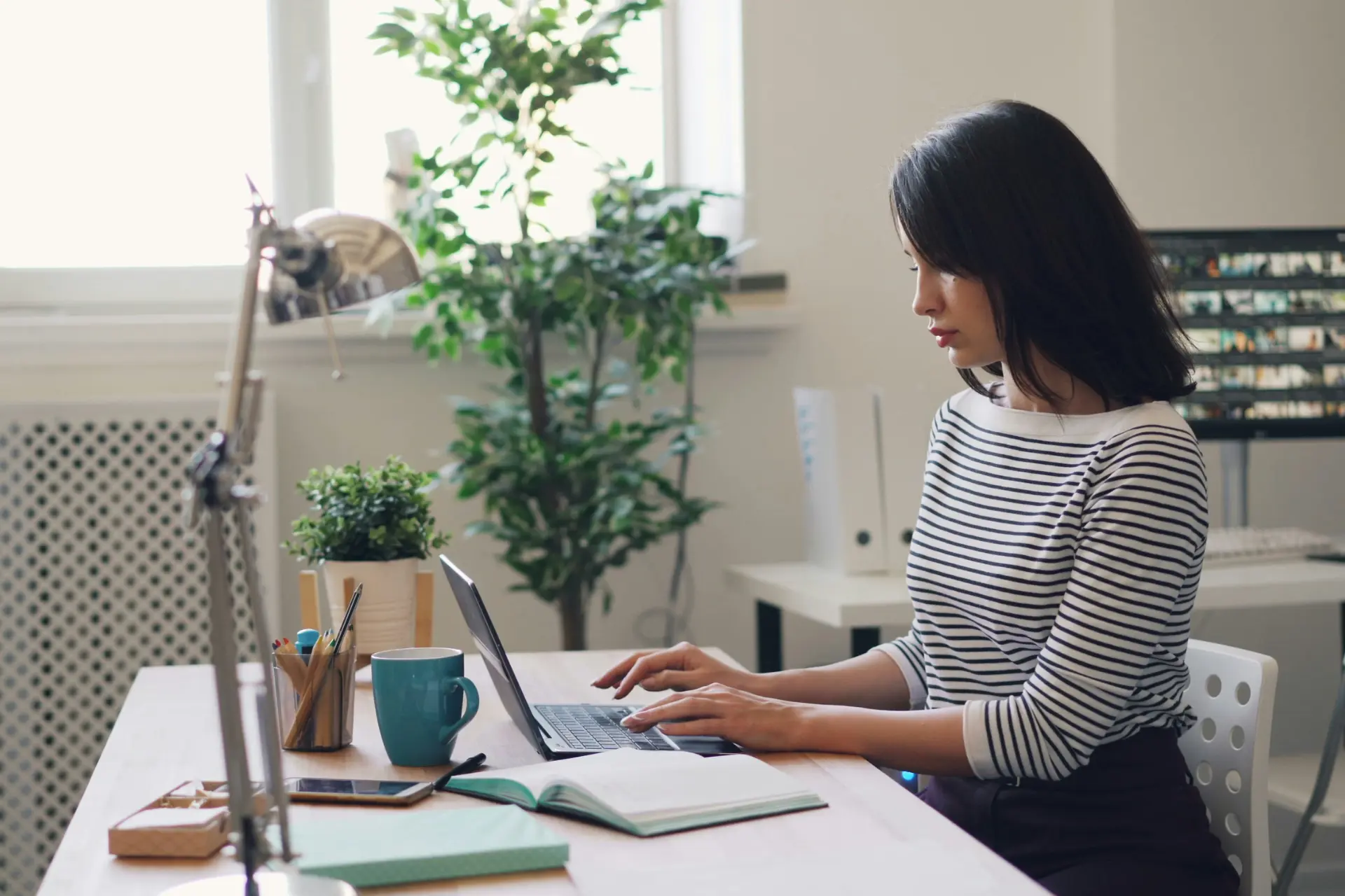 a woman sitting at a desk using a laptop