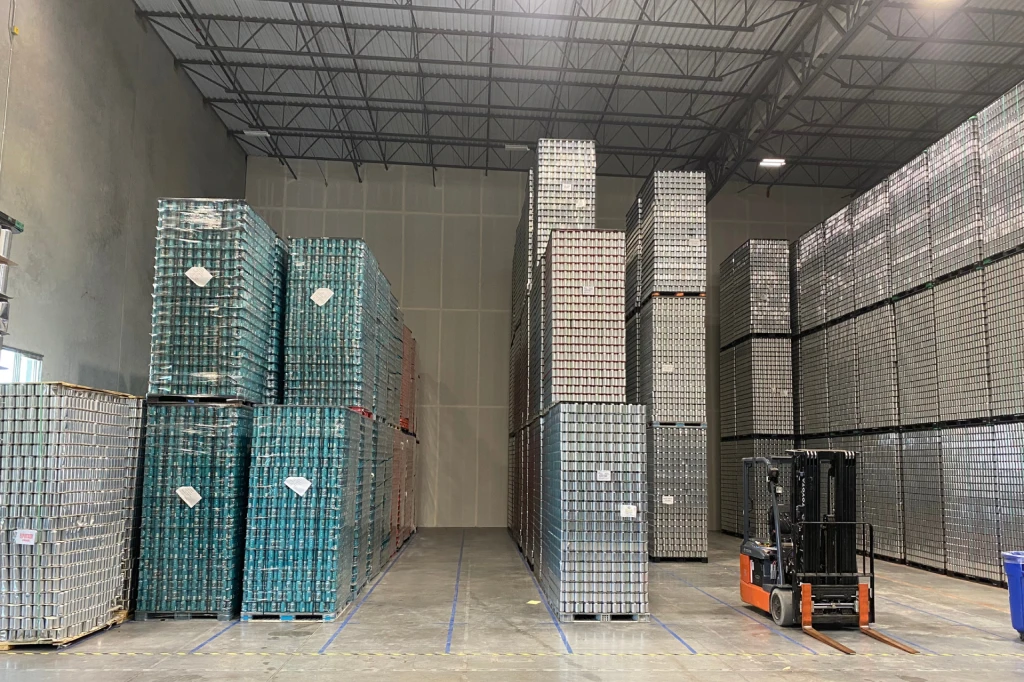 a warehouse with pallet stacks of cans 