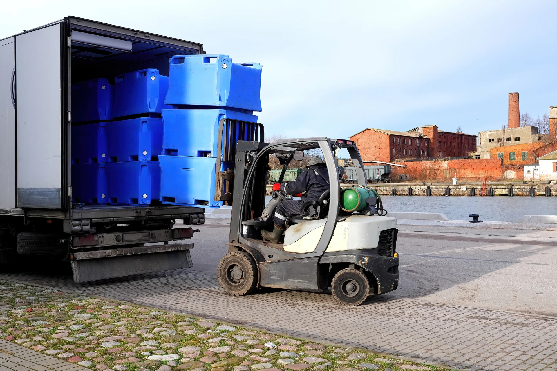 Forklift driver loading crates into a refrigerated truck