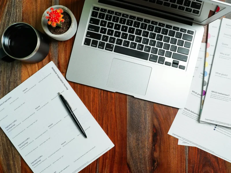 a laptop and paperwork on a wooden table