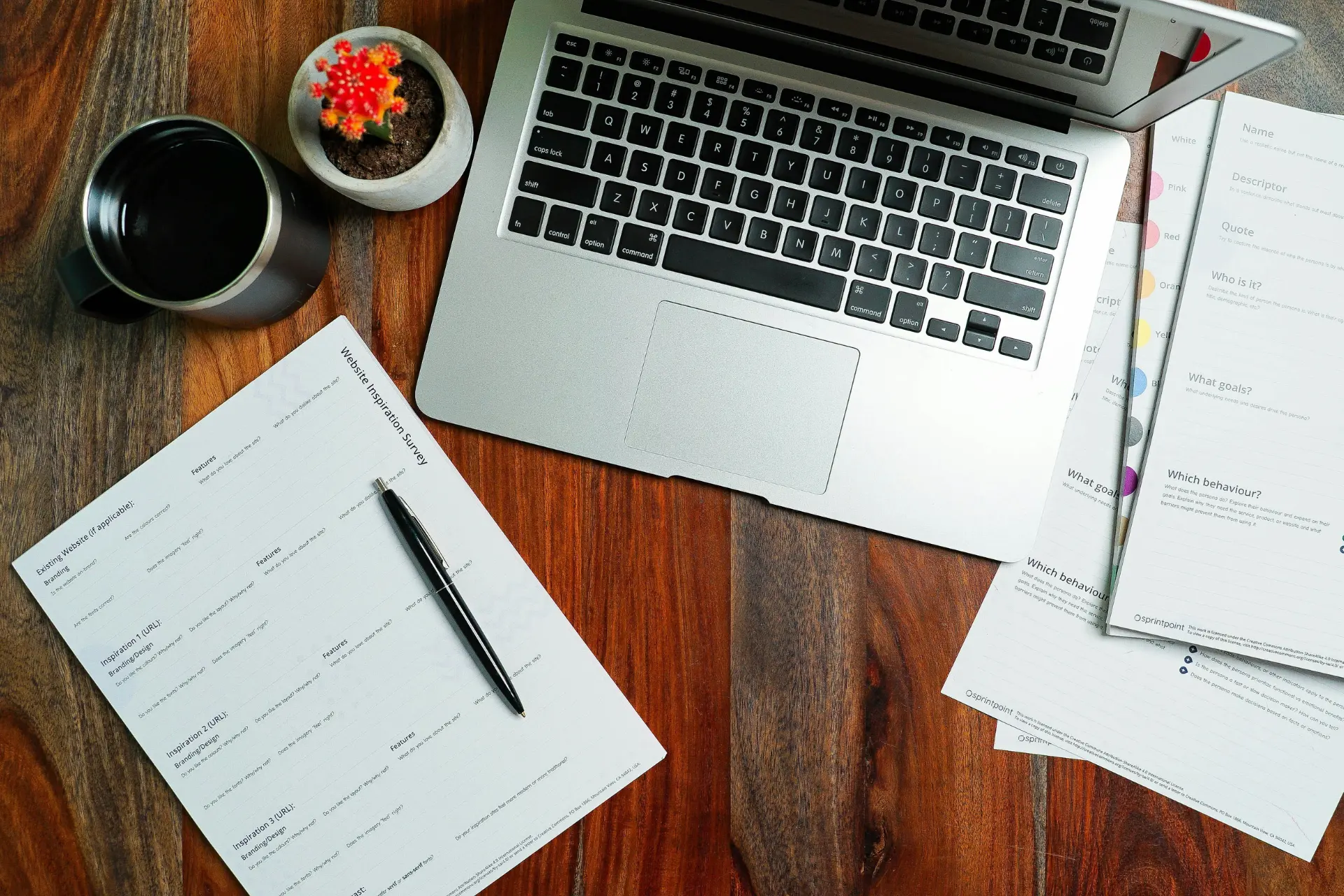 a laptop and paperwork on a wooden table